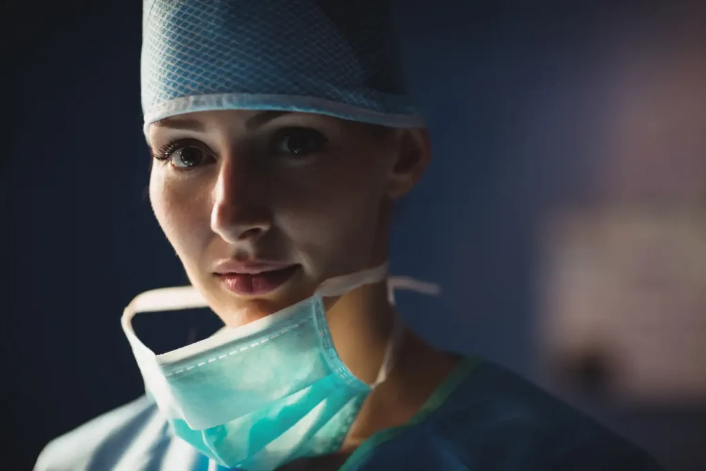 A nurse in full PPE looks at the camera. She seems stressed and would be a good candidate for a care for carers therapy session.